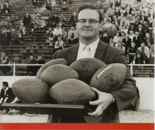 AFL and Kansas City Chief founder Lamar Hunt holding a platter of AFL footballs.